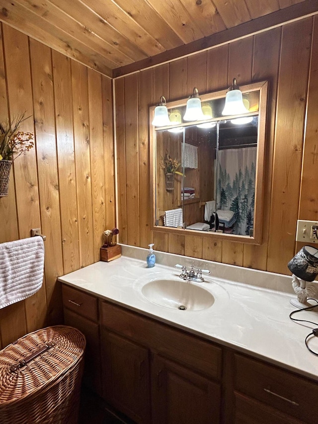 bathroom featuring wood walls, vanity, and wooden ceiling