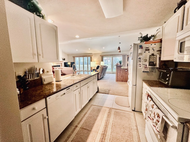 kitchen with sink, light tile patterned floors, white cabinetry, a textured ceiling, and white appliances