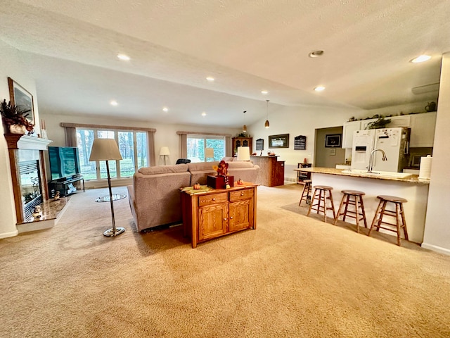 living room with vaulted ceiling, light carpet, and a textured ceiling