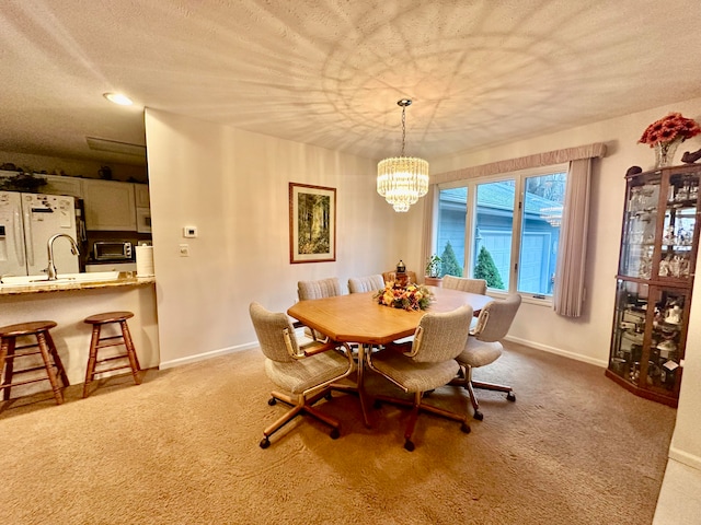 carpeted dining room with a chandelier and a textured ceiling