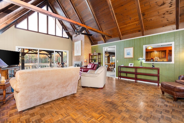 living room featuring dark parquet flooring, high vaulted ceiling, a brick fireplace, beamed ceiling, and ceiling fan