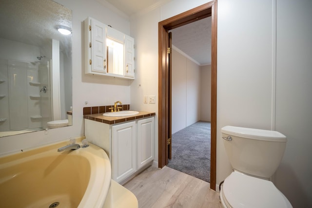 bathroom with vanity, crown molding, a textured ceiling, and hardwood / wood-style flooring