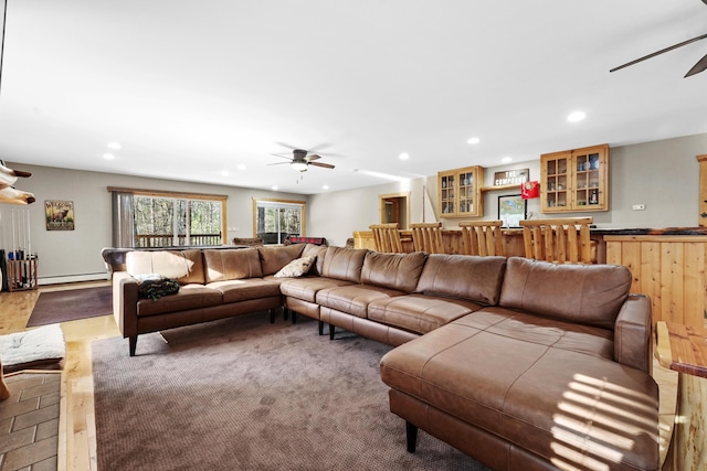 living room with bar area, a baseboard radiator, and ceiling fan