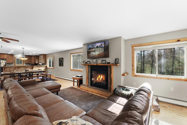 living room with ceiling fan, light hardwood / wood-style floors, and a baseboard radiator