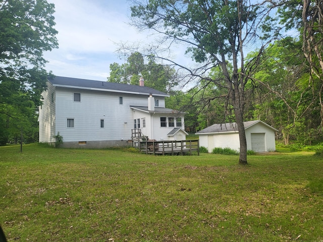 rear view of house featuring a garage, an outdoor structure, and a yard