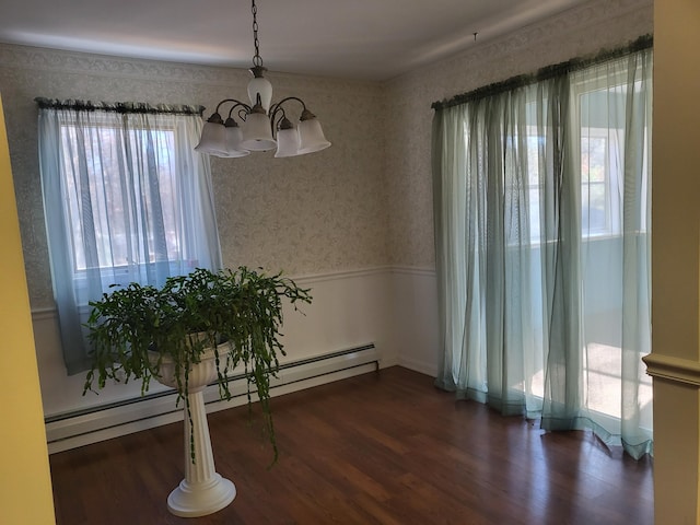 dining area with dark wood-type flooring, an inviting chandelier, baseboard heating, and a healthy amount of sunlight