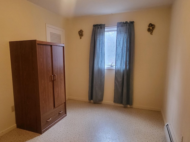 unfurnished bedroom featuring a closet and a baseboard radiator