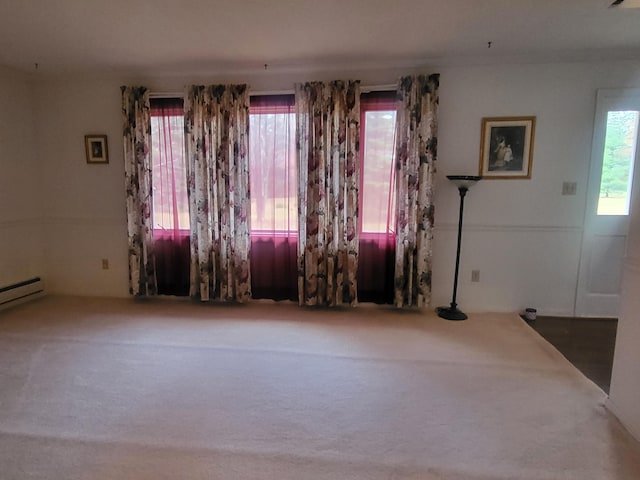 unfurnished room featuring a baseboard radiator and carpet floors