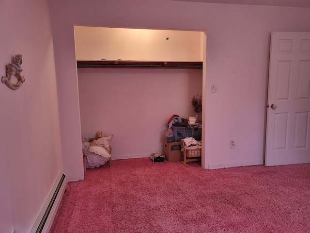 unfurnished bedroom with a closet, carpet floors, and a baseboard heating unit