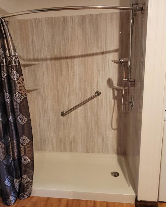 bathroom with walk in shower and hardwood / wood-style floors