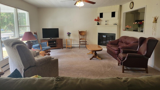 carpeted living room featuring ceiling fan, baseboard heating, a large fireplace, and plenty of natural light