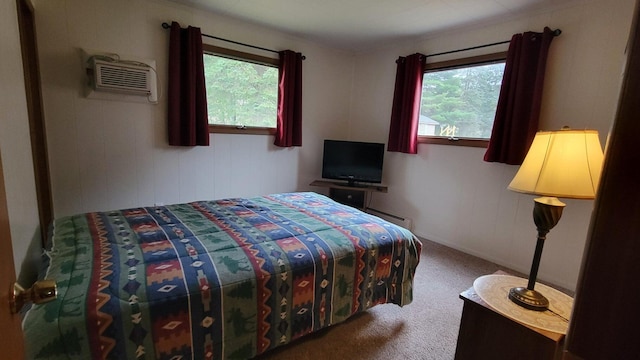 carpeted bedroom with a wall unit AC and baseboard heating