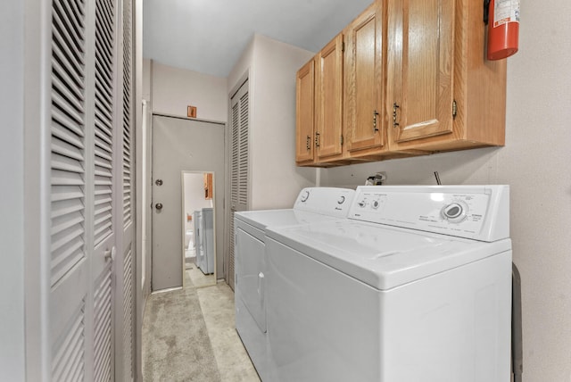 laundry room with washing machine and dryer and cabinets