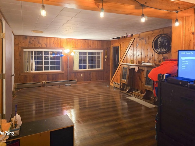 interior space featuring hardwood / wood-style flooring, wood walls, and a baseboard radiator