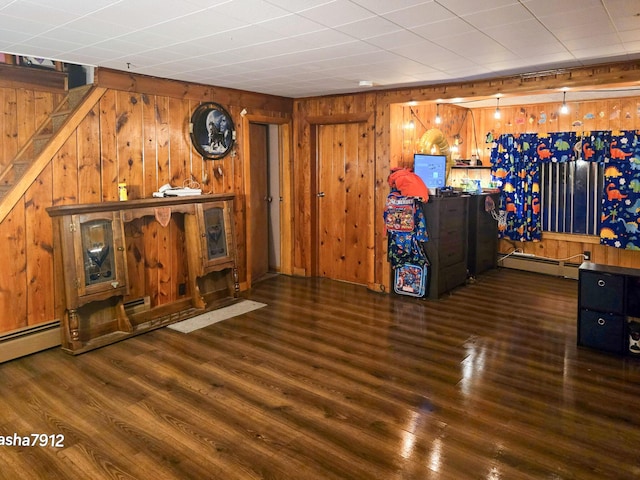 interior space featuring wooden walls, a baseboard radiator, and dark hardwood / wood-style floors