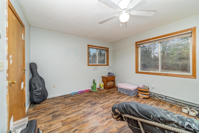 miscellaneous room featuring wood-type flooring, a textured ceiling, and ceiling fan