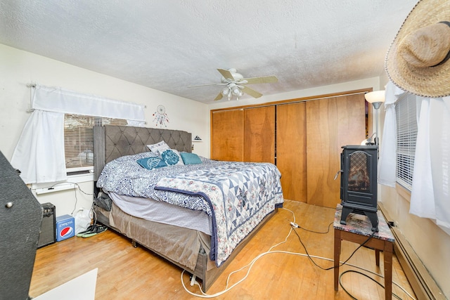 bedroom featuring wood-type flooring, a textured ceiling, and ceiling fan