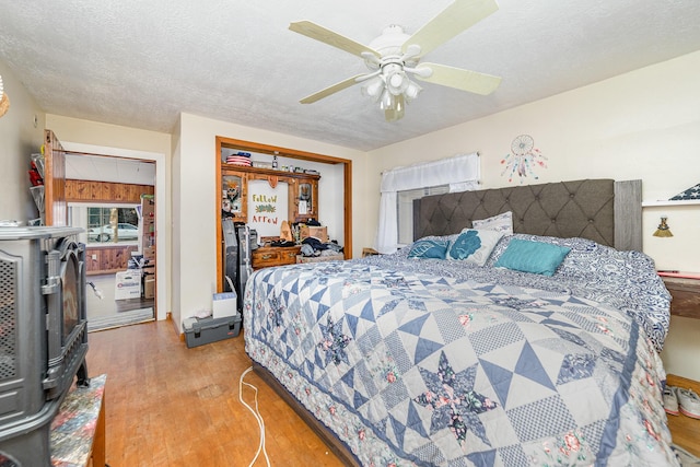 bedroom featuring a textured ceiling, a closet, ceiling fan, and light hardwood / wood-style floors