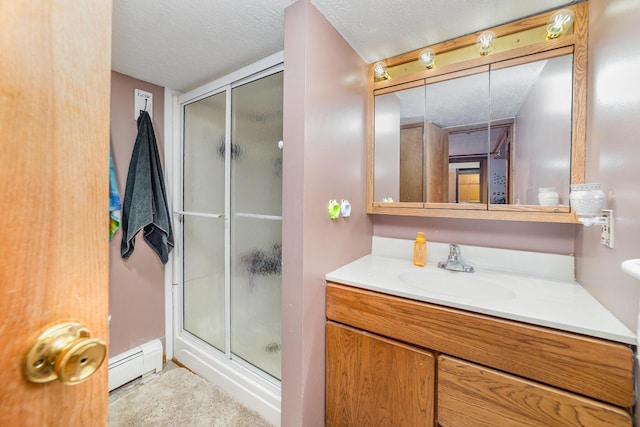 bathroom with a shower with door, vanity, a textured ceiling, and baseboard heating