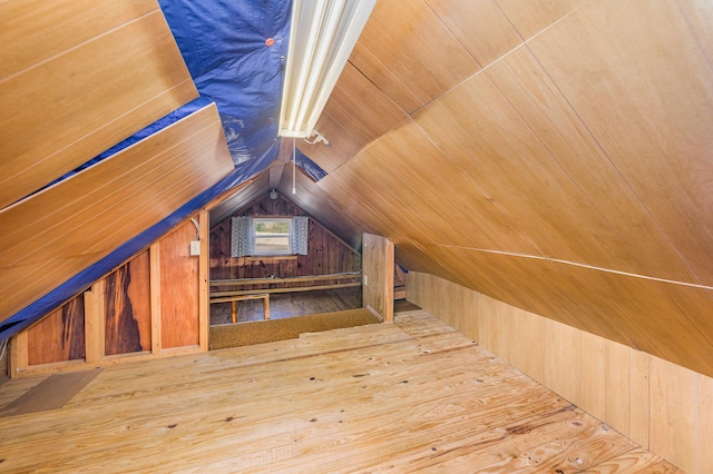 bonus room featuring wooden walls and vaulted ceiling