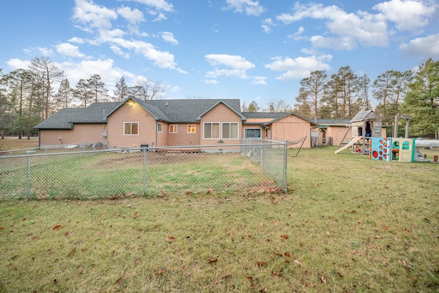 back of house with a yard and a playground