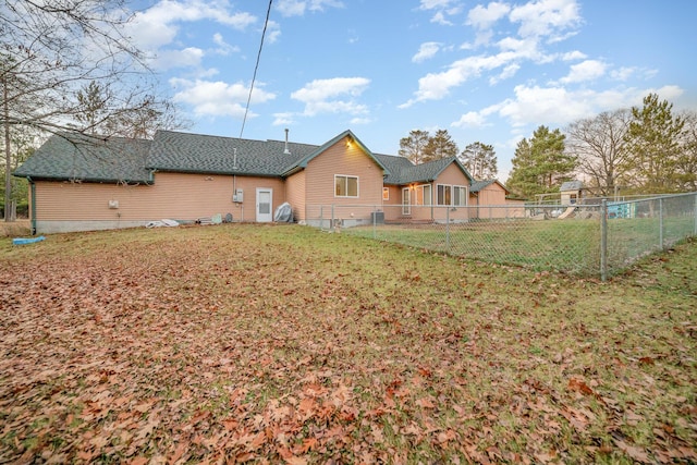 back of house featuring central AC unit and a yard