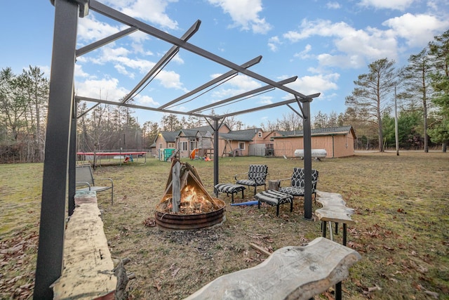 view of yard with a fire pit, a storage unit, and a trampoline