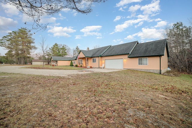 ranch-style home with a garage and a front lawn