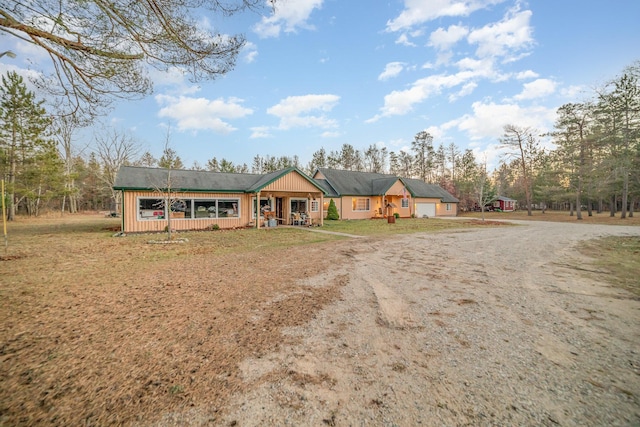 single story home with a front yard, covered porch, and a garage