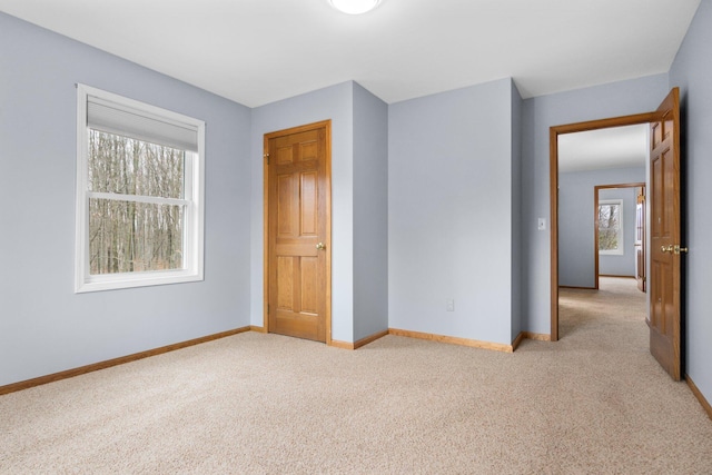 unfurnished bedroom featuring multiple windows and light colored carpet