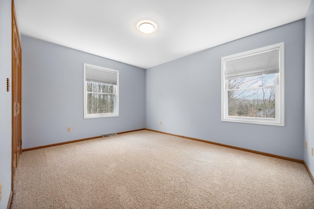 carpeted spare room featuring a wealth of natural light