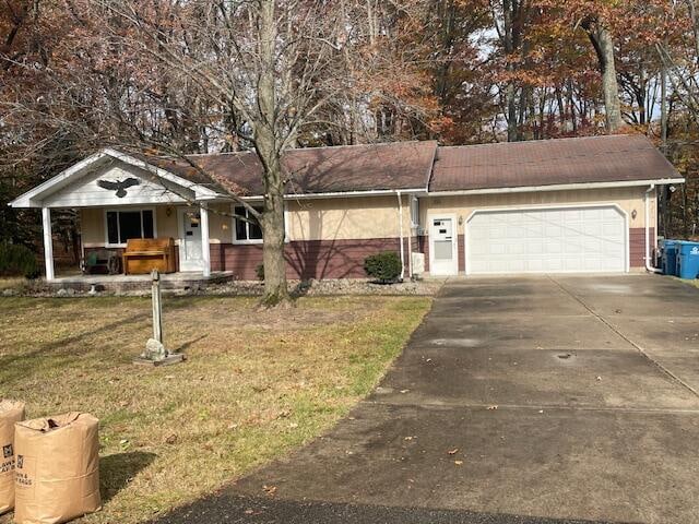 ranch-style house with covered porch, a garage, and a front yard