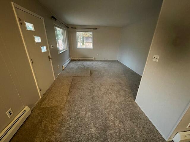 unfurnished room featuring a baseboard radiator and carpet floors