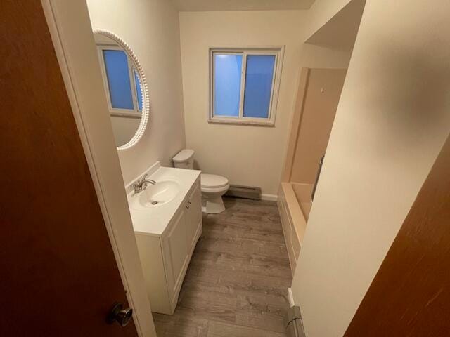 full bathroom with vanity, independent shower and bath, hardwood / wood-style floors, a baseboard radiator, and toilet