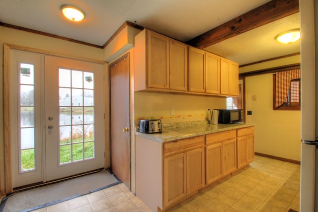 kitchen featuring plenty of natural light, beam ceiling, crown molding, and light brown cabinetry