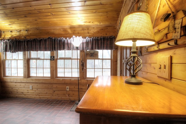 unfurnished dining area featuring wooden walls, wooden ceiling, and a healthy amount of sunlight