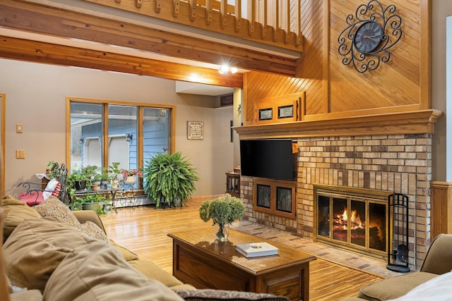 living room with a brick fireplace, hardwood / wood-style floors, and wood walls