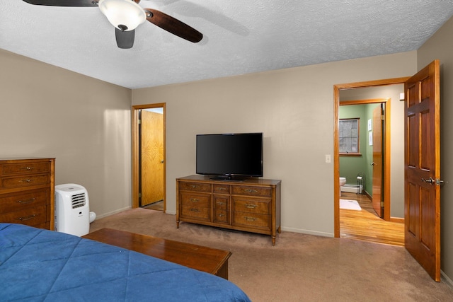 bedroom with a textured ceiling, baseboard heating, light carpet, and ceiling fan