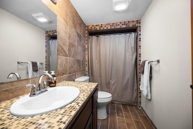 bathroom featuring toilet, vanity, tile walls, and hardwood / wood-style flooring