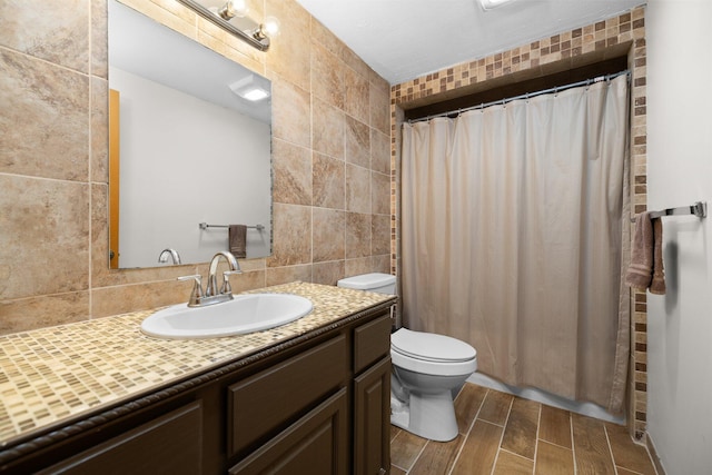 bathroom featuring a shower with curtain, vanity, toilet, and tile walls