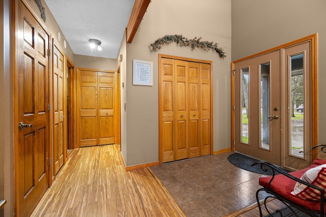 entryway with dark hardwood / wood-style floors, a textured ceiling, and lofted ceiling with beams