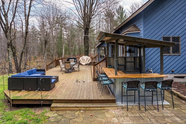 wooden deck featuring a bar and outdoor lounge area