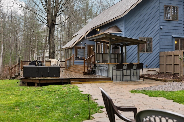 back of house with an outdoor bar, a yard, and a deck