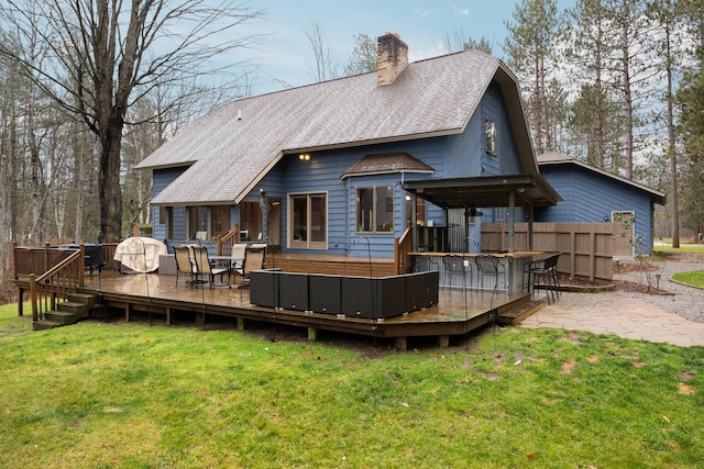 back of house with a lawn, exterior bar, and a wooden deck