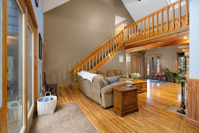 living room with light hardwood / wood-style floors and high vaulted ceiling