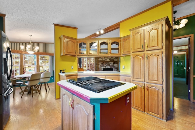 kitchen with a center island, a notable chandelier, light hardwood / wood-style floors, decorative light fixtures, and black stovetop