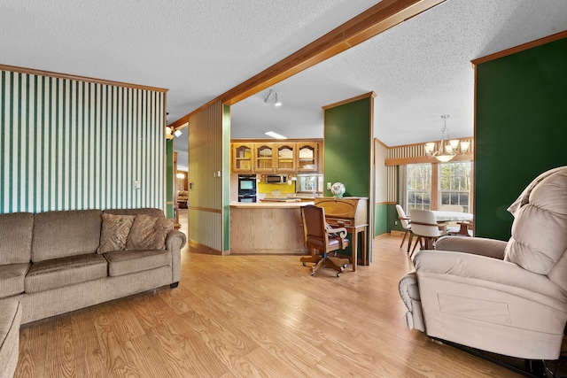 living room featuring vaulted ceiling with beams, light hardwood / wood-style flooring, a textured ceiling, and a notable chandelier