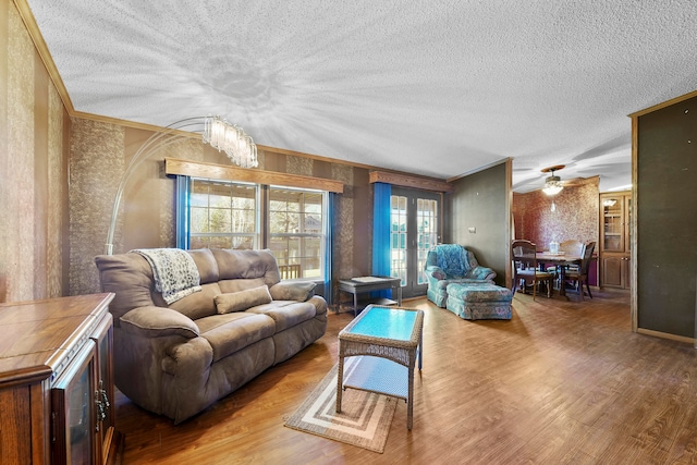 living room with a textured ceiling, hardwood / wood-style flooring, and crown molding