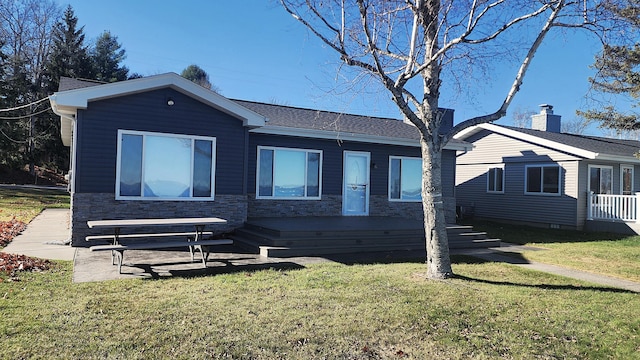 view of front of home featuring a front yard and a deck