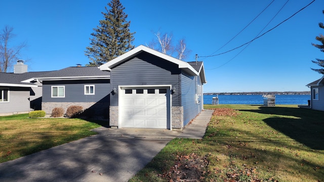 view of side of home featuring a garage, a water view, and a lawn